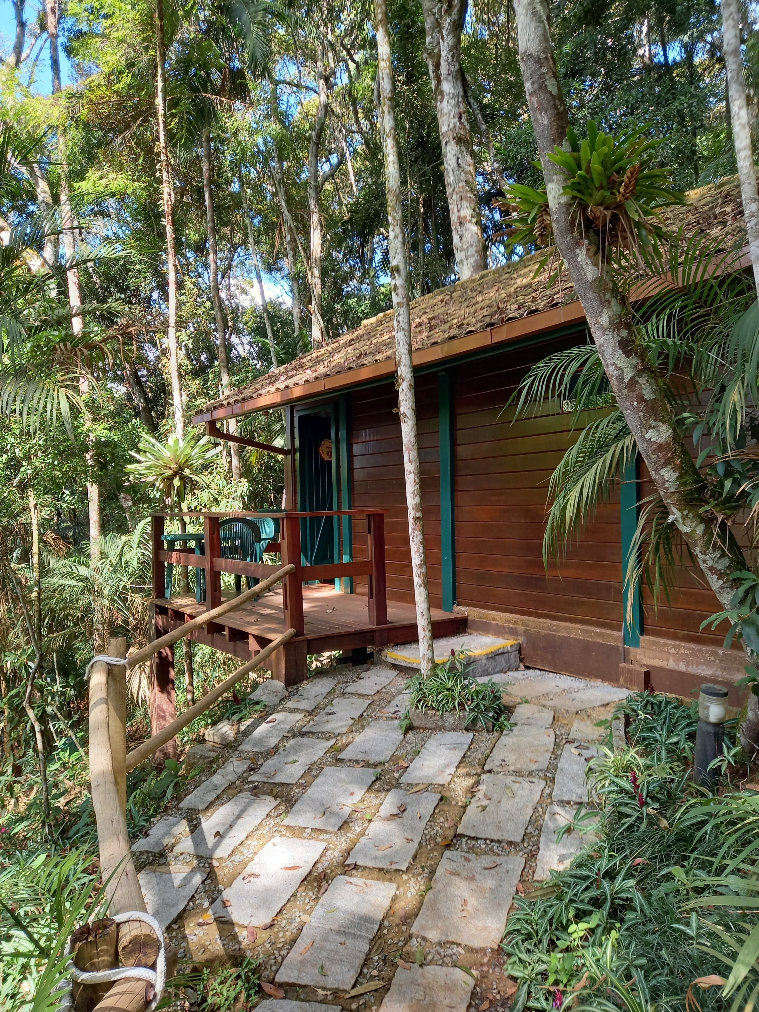 A wooden cabin with a wooden deck and stairs leading to the entrance.