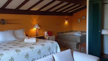 Una habitación de hotel con dos camas, un área de descanso, una bañera y un candelabro.