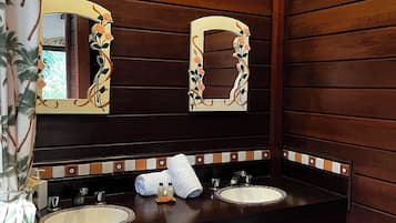 A bathroom with wooden paneling, two sinks with mirrors, and a tiled backsplash.
