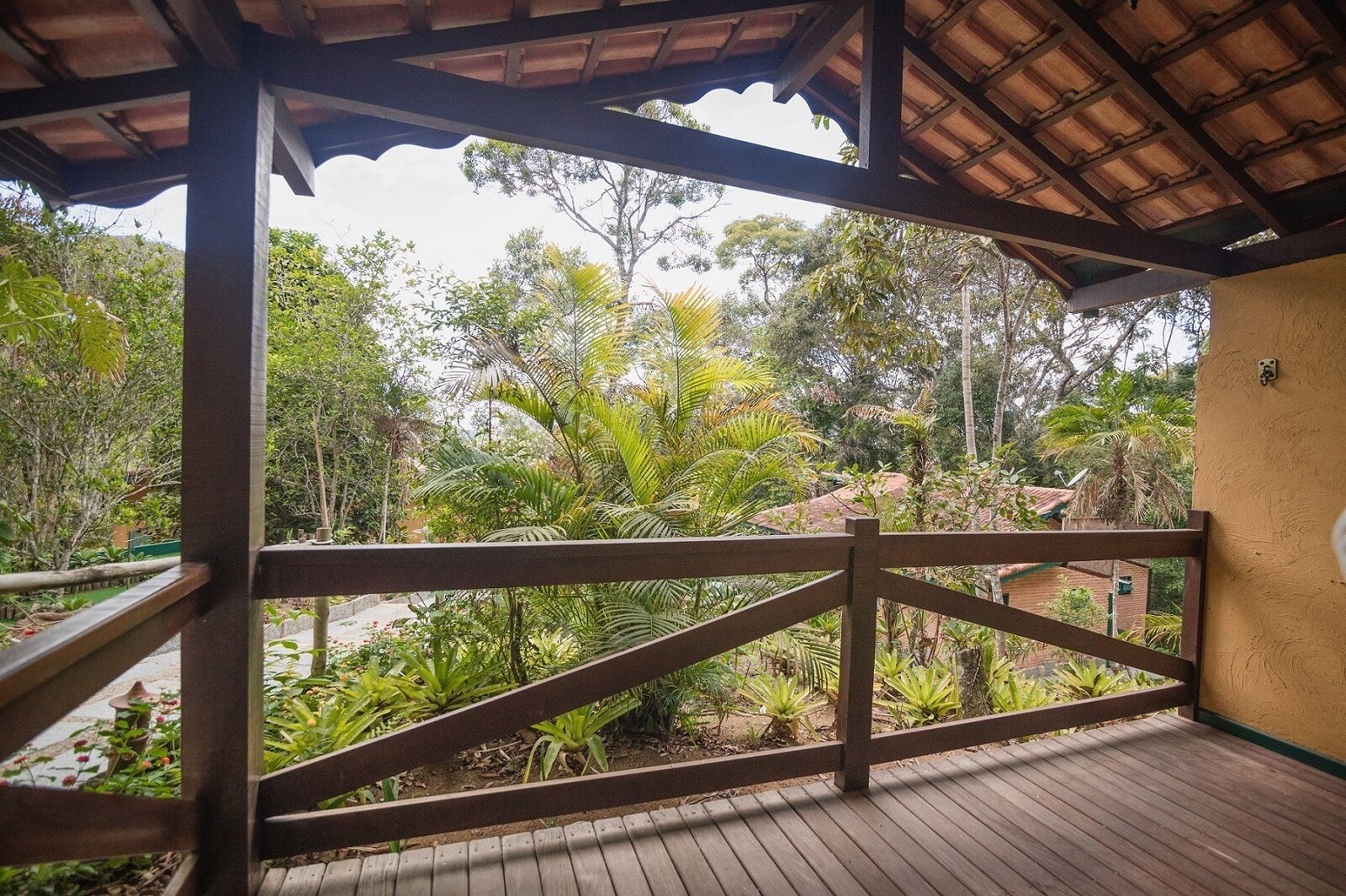 A wooden deck with a view of a garden and trees.