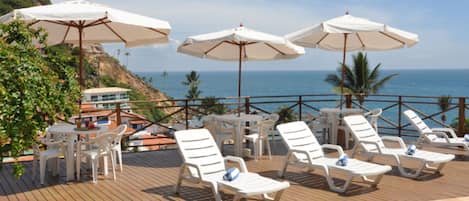 Una piscina al aire libre, sillones reclinables de piscina