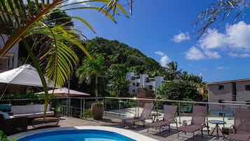 Una piscina al aire libre, sillones reclinables de piscina