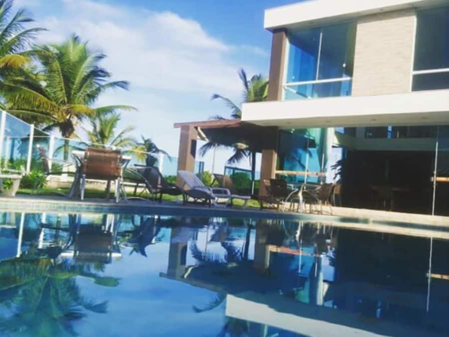 Alberca al aire libre, sombrillas en la alberca y camastros