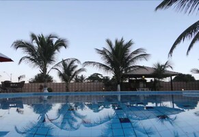 Una piscina al aire libre, sombrillas, tumbonas