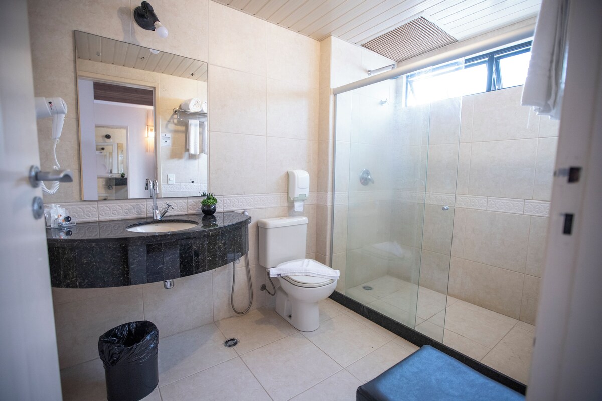 Une salle de bain moderne avec un lavabo, des toilettes et une douche à parois de verre.
