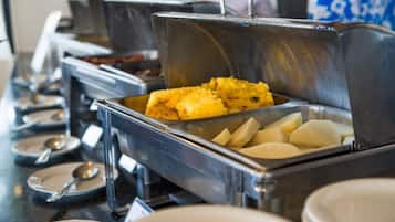 A buffet setup with various food items in metal containers.