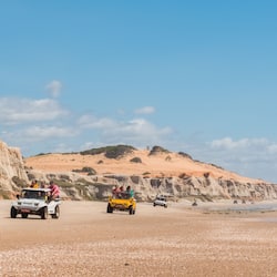 Na praia, areia branca, toalhas de praia