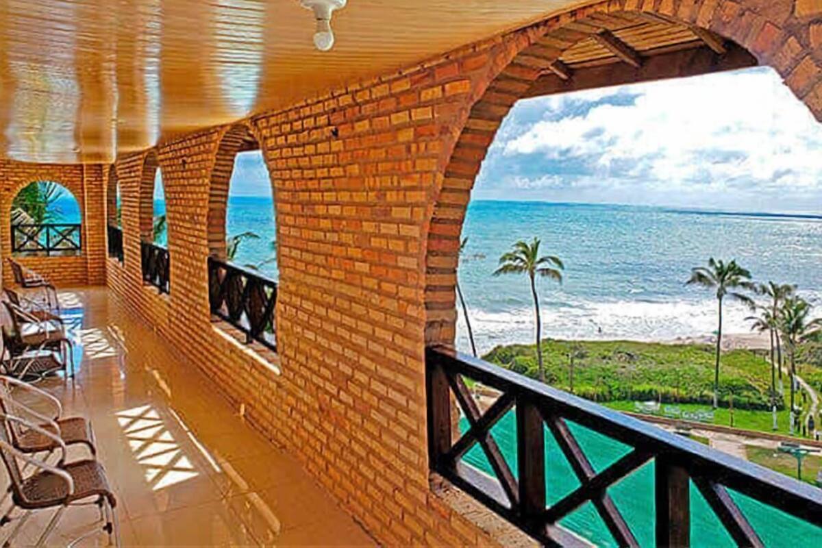 A covered outdoor area with brick walls and a view of the ocean.