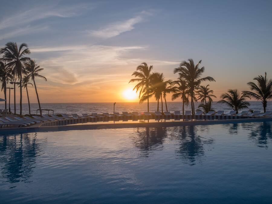 Una piscina al aire libre, sillones reclinables de piscina