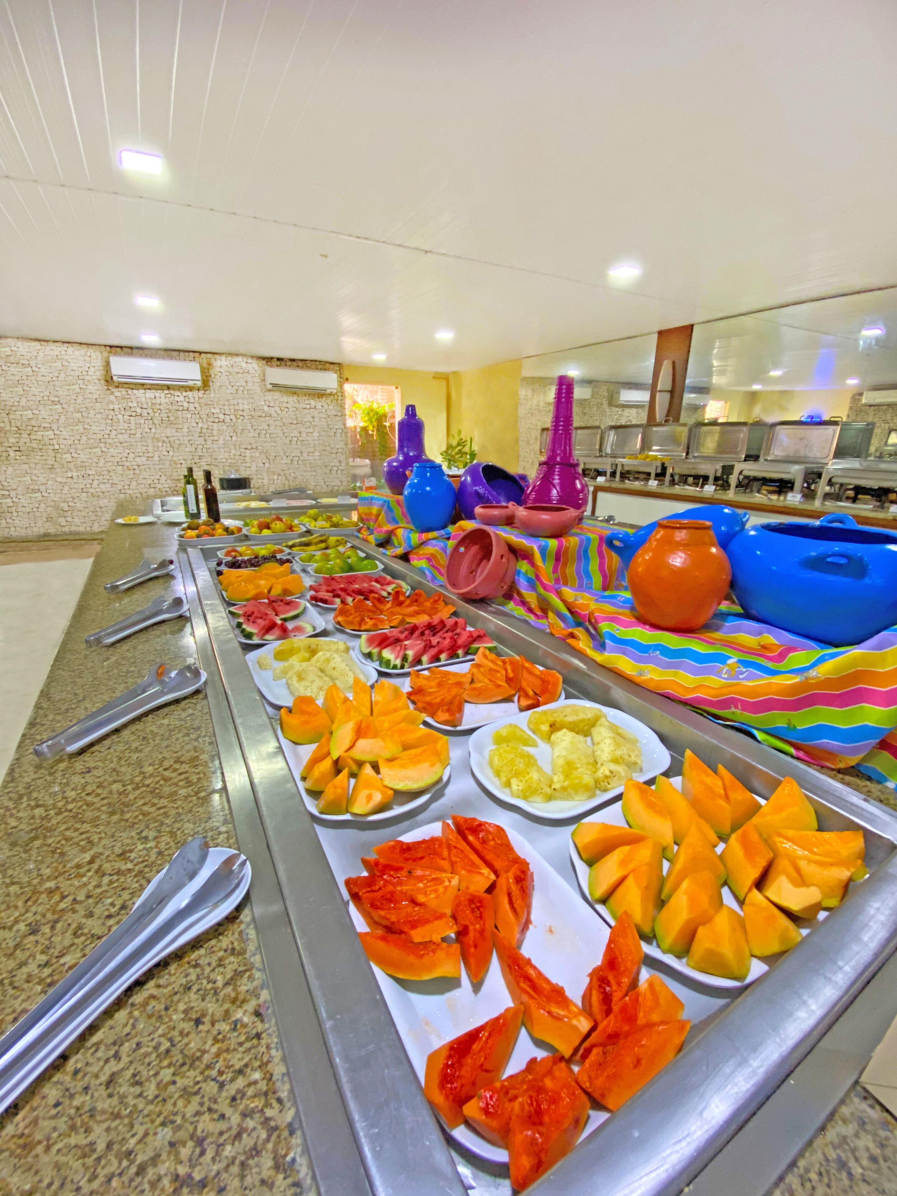 A buffet with various fruits and vegetables, including watermelon, cantaloupe, and pineapple.