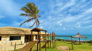 A playground with a slide, swings, and a palm tree. - Hotel Parque das Fontes All Inclusive (Beberibe)