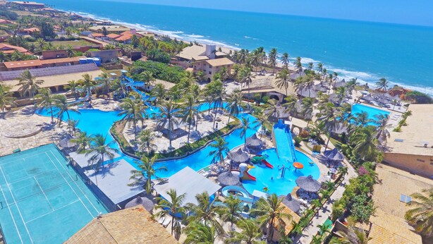 An aerial view of a resort with a large swimming pool, palm trees, and a beach. - Hotel Parque das Fontes All Inclusive (Beberibe)