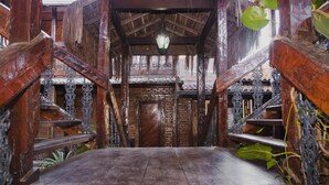 A wooden staircase with ornate metal railings leading to a door. - Quari Quara BY MN Hotéis (Rio das Ostras)