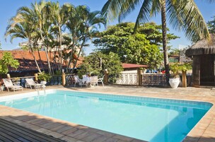 Una piscina con tumbonas y palmeras.