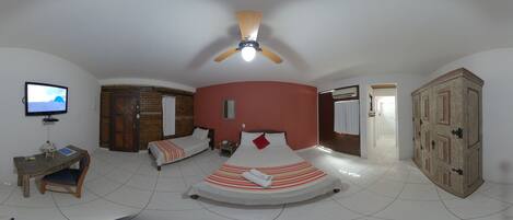 Une chambre avec un lit, un bureau, une télévision et une armoire.