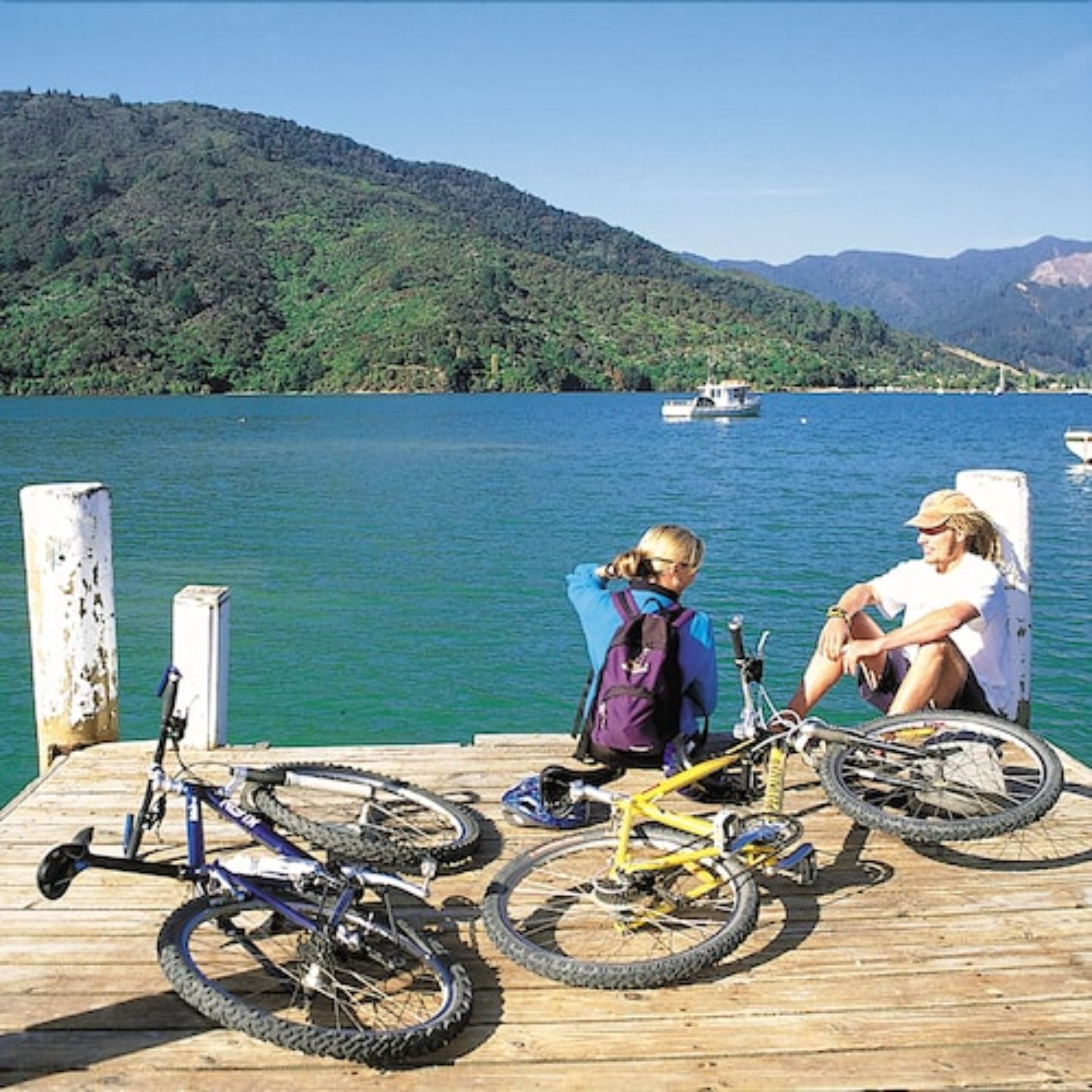 A wooden dock with bicycles and a person sitting.