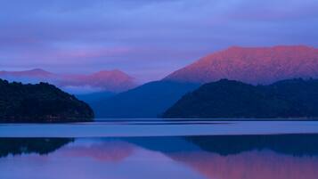 A calm lake with mountains in the background.