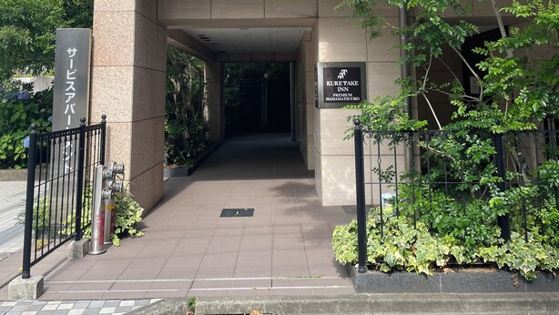 L’entrée d’un immeuble, avec une enseigne indiquant « Kure Take Inn Premium Hamamatsucho ».