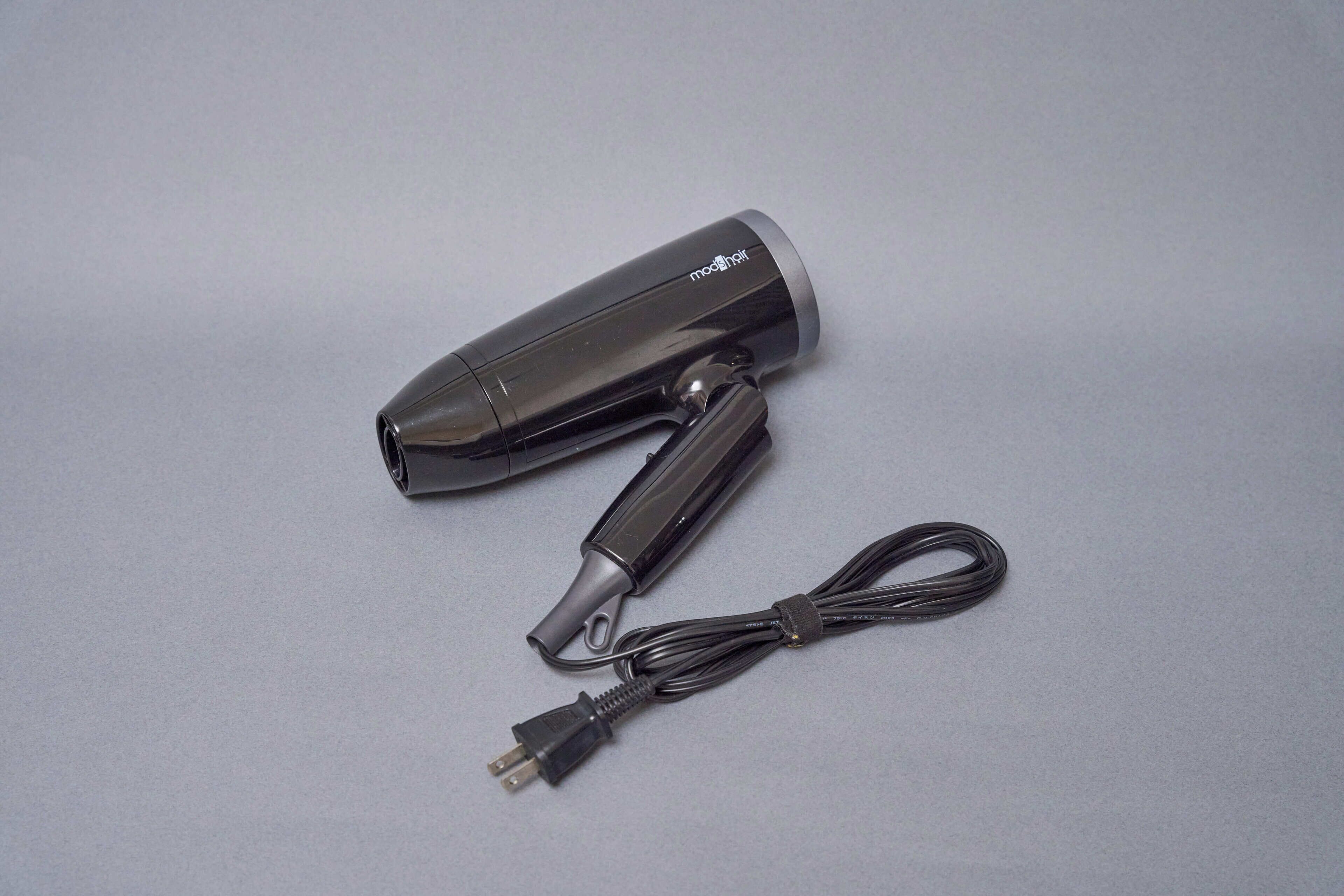 A black hair dryer with a cord and plug.