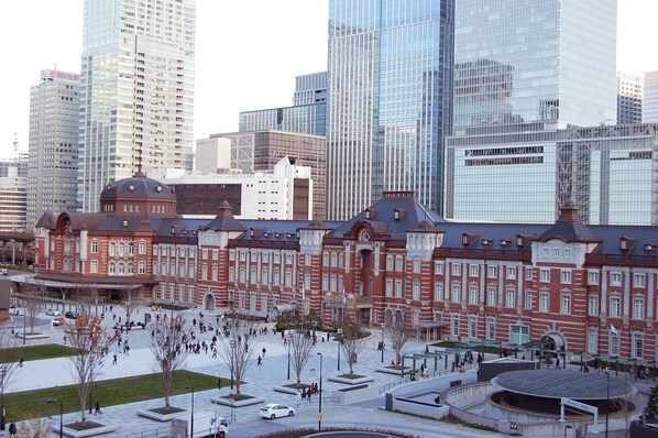 A historic building with a central dome and symmetrical architecture, surrounded by modern high-rise buildings.