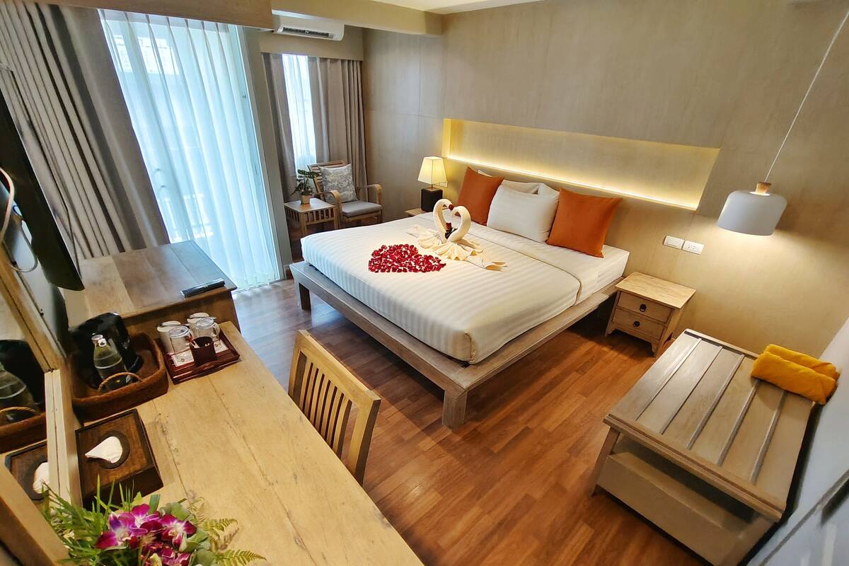 Une chambre d’hôtel avec un grand lit, des tables de chevet, un bureau et une chaise.