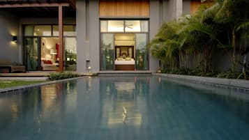Una piscina al aire libre, sillones reclinables de piscina