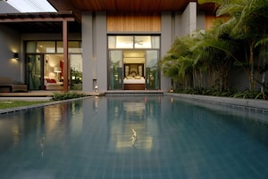 Una piscina al aire libre, sillones reclinables de piscina