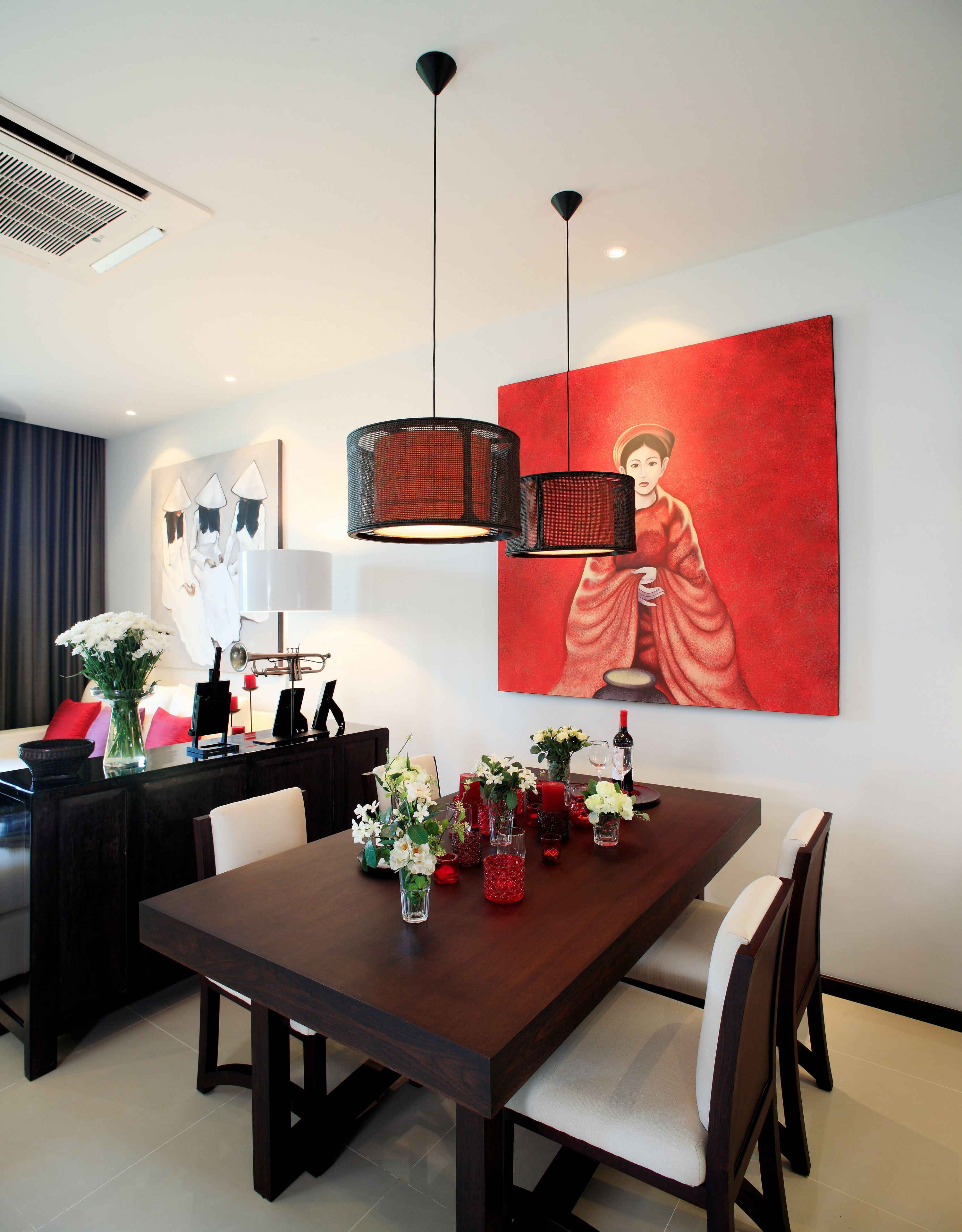 A modern dining area with a wooden table, chairs, and a large red painting on the wall.