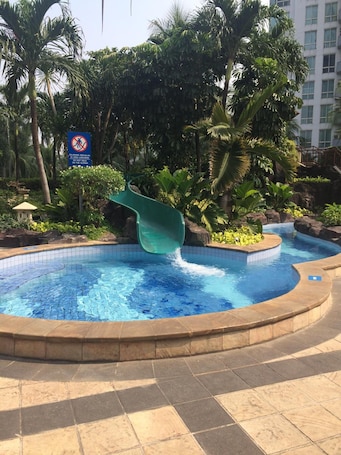Una piscina al aire libre, sillones reclinables de piscina