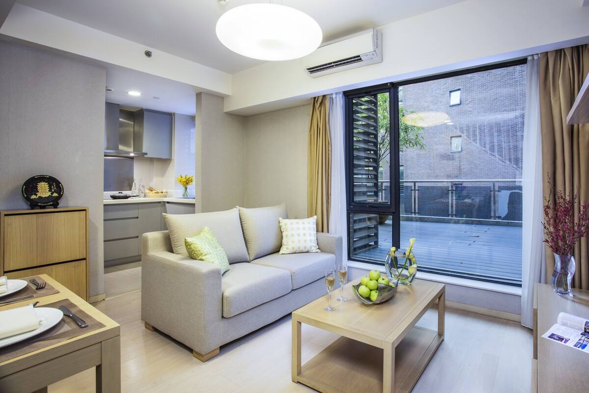 A modern living room with a sofa, coffee table, and dining area.