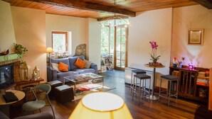 Un salon chaleureux avec une cheminée, un canapé, une table basse et une lampe.