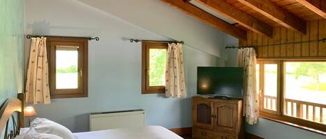Un dormitorio con cama, televisor y aparador de madera.