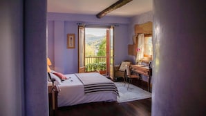 Une chambre à coucher avec un lit, un bureau et une vue sur l’extérieur.