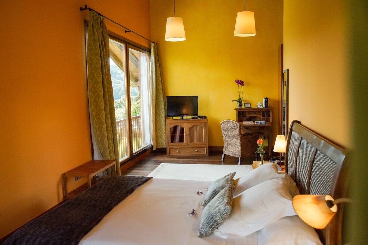 A hotel room with a bed, a television, a desk, and a chair.