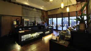 A modern kitchen with a central island, overhead lighting, and a view of the sea. - Grand Setiabudi Hotel (Bandung)