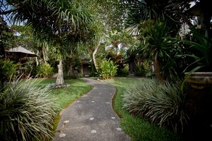 Stroll through lush gardens to a serene retreat, surrounded by tropical vegetation and a tranquil atmosphere.