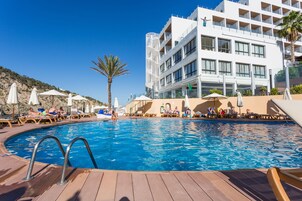 Una piscina al aire libre, sombrillas, tumbonas