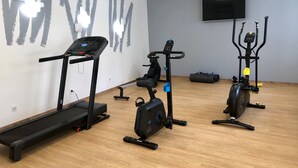 Gimnasio con cintas de correr, elíptica y bicicleta estática.