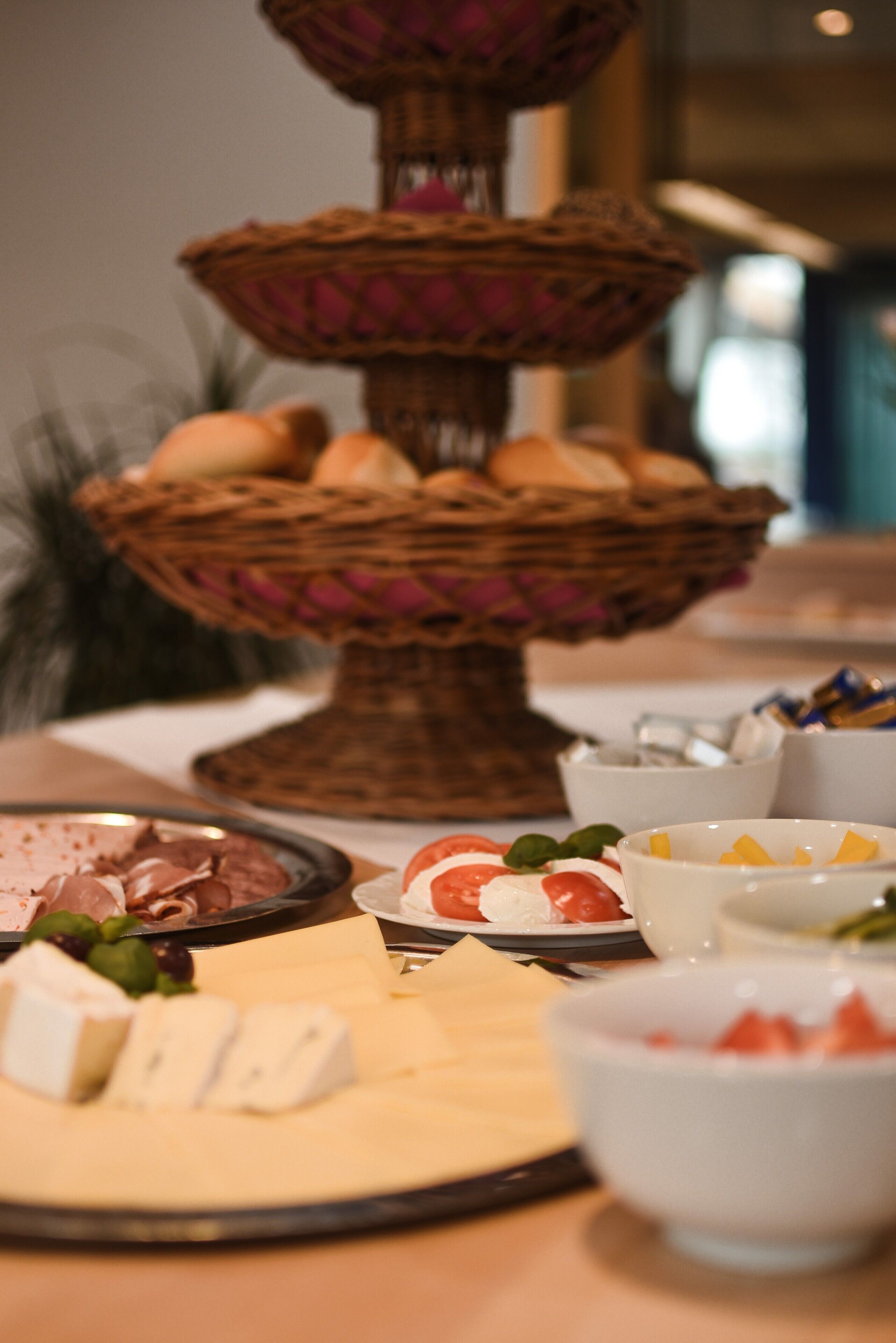 Een buffet met diverse soorten eten, waaronder kazen, vleeswaren en fruit.