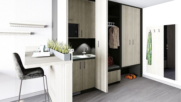 A modern, compact room with a built-in desk, a sink, and a wardrobe with a hanging space. - Hotel Rieth (Boeblingen)