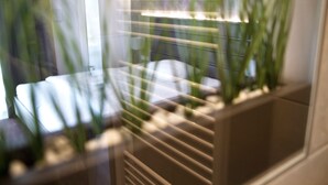 A blurred view of a room with a window, a plant, and a bed. - Hotel Rieth (Boeblingen)