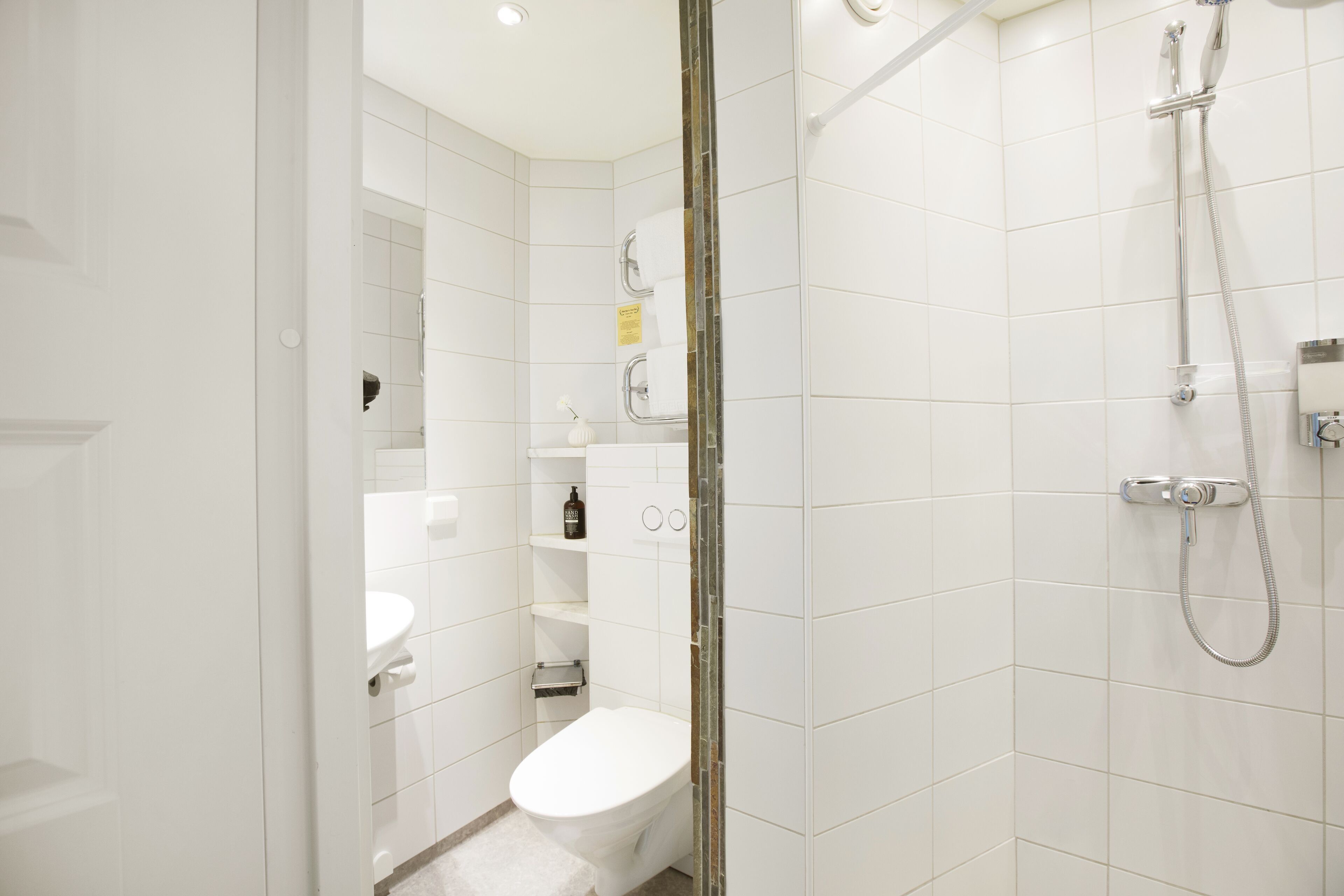 Un baño moderno con inodoro, lavamanos y ducha.