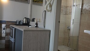 A modern kitchen with a built-in stove, a coffee maker, and a kettle on the counter. - Family Bikakis (Kissamos)