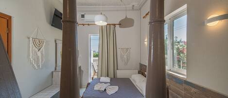 A bedroom with a bed, a window, a ceiling fan, and a wall-mounted air conditioning unit.