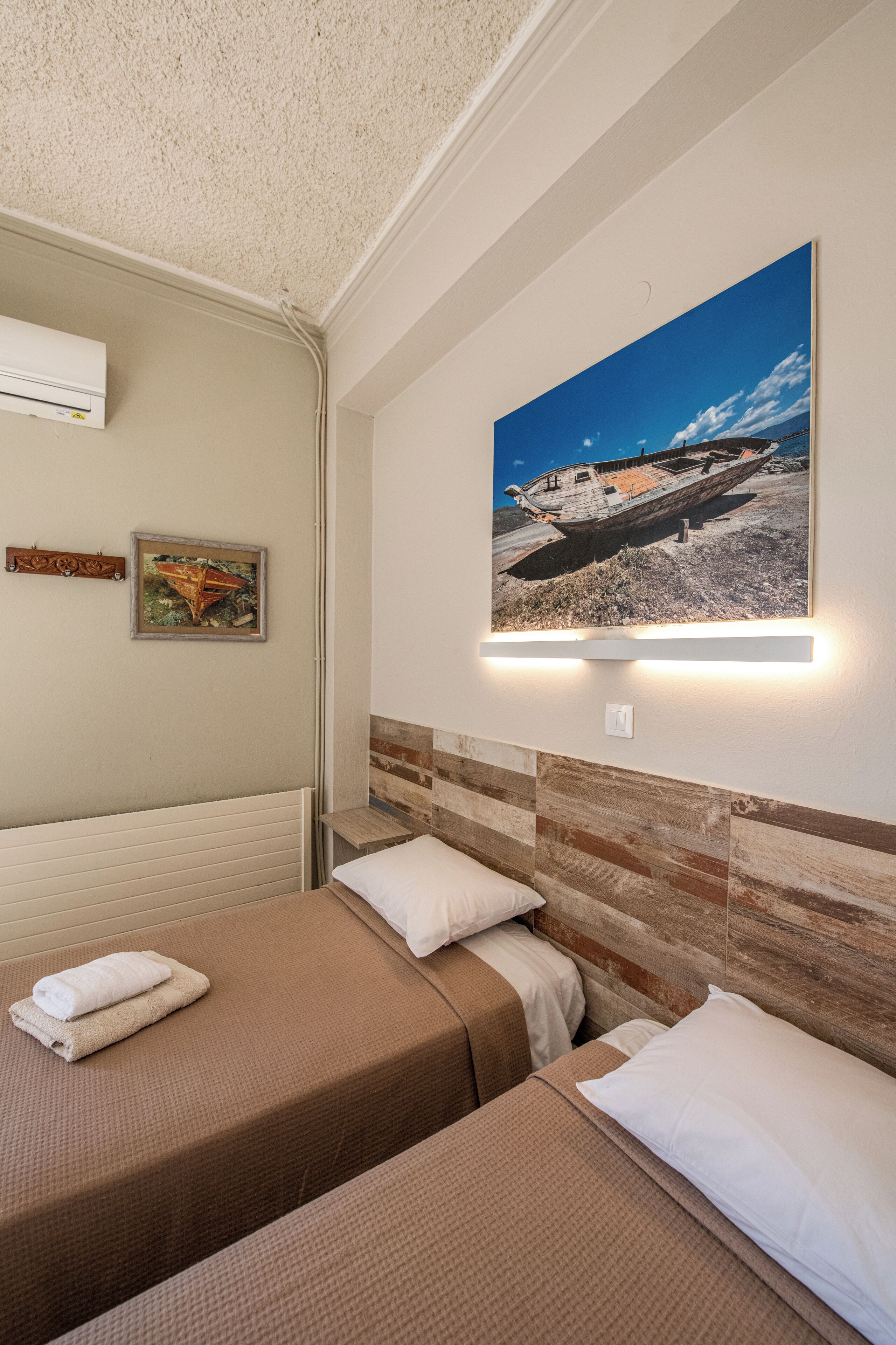 Habitación de hotel con dos camas, un cuadro colgado en la pared y un radiador.