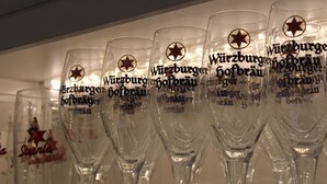 A row of clear wine glasses with text and a star logo, likely for a specific brand or event. - Gasthof Hausmann (Schluechtern)