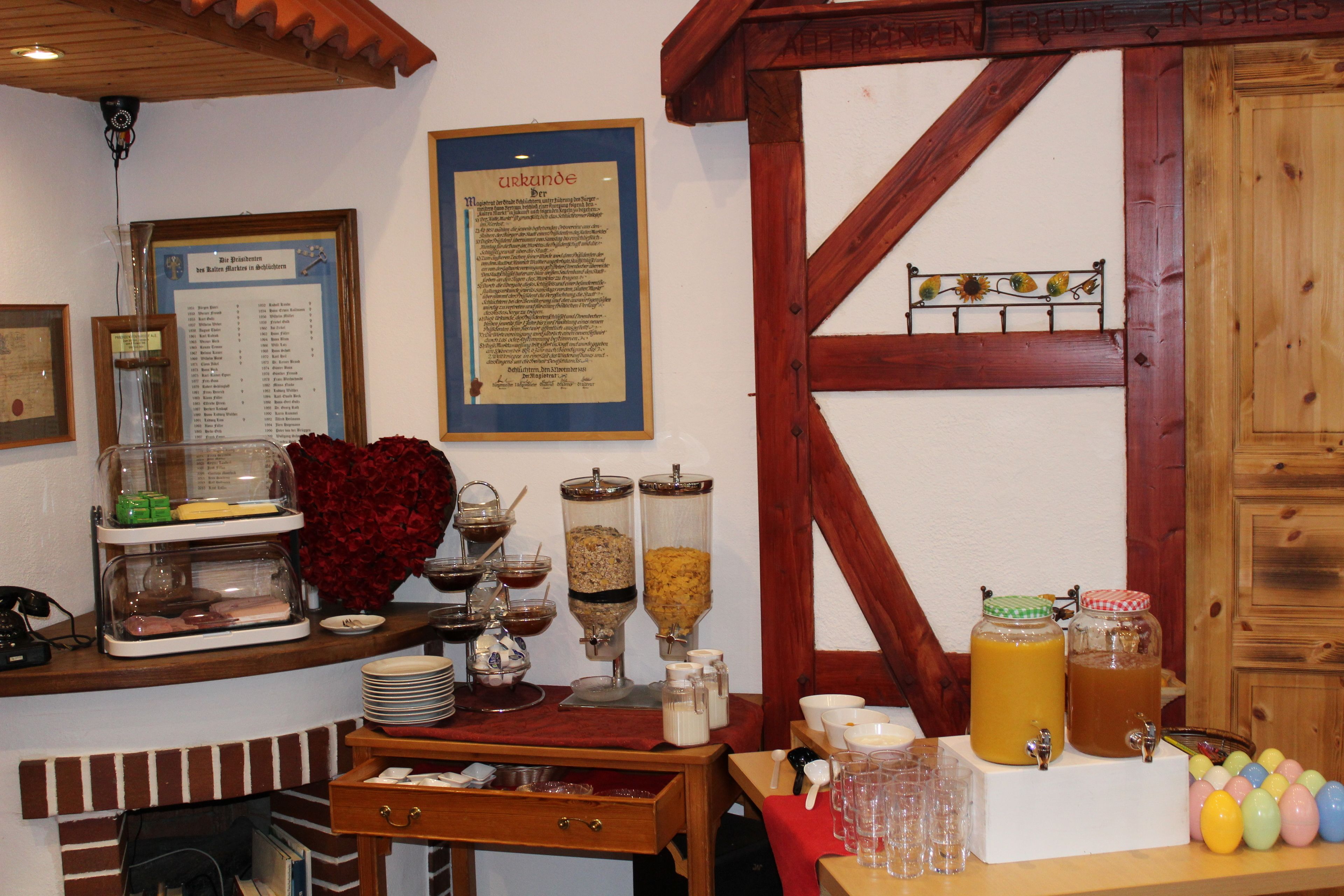 A breakfast bar with various food items and beverages, a framed menu, and a wooden interior.