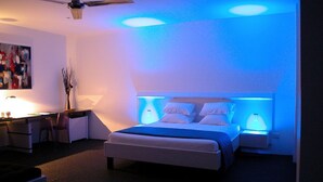 Een slaapkamer met een bed, bedlampen, een bureau en een stoel.
