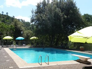 Una piscina al aire libre, sombrillas, tumbonas