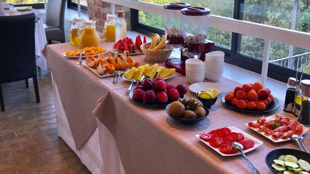 Un tavolo per buffet con una varietà di frutta e bevande, con vista su un panorama suggestivo.